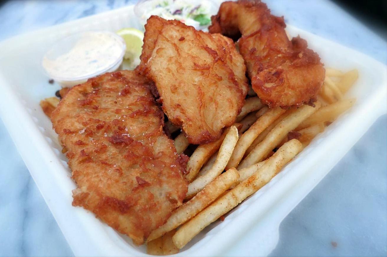 closeup of 3-piece fish and chips with Old Bay fries and tartar sauce