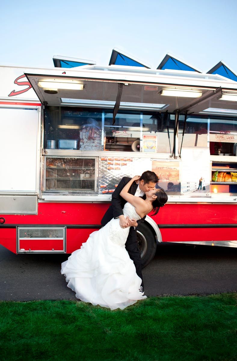 newlyweds pose for a dramatic kiss in front of Sam's ChowderMobile at their outdoor Bay Area wedding reception