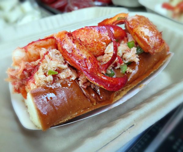 closeup of lobster roll sandwich from Sam's ChowderMobile features delicious Maine lobster lightly tossed in warmed butter on a toasted bun