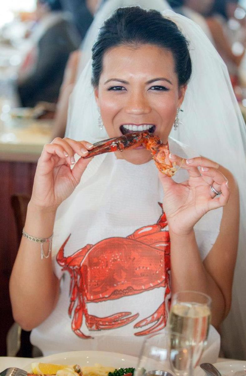 bride wearing crab bib while enjoying eating lobster claw